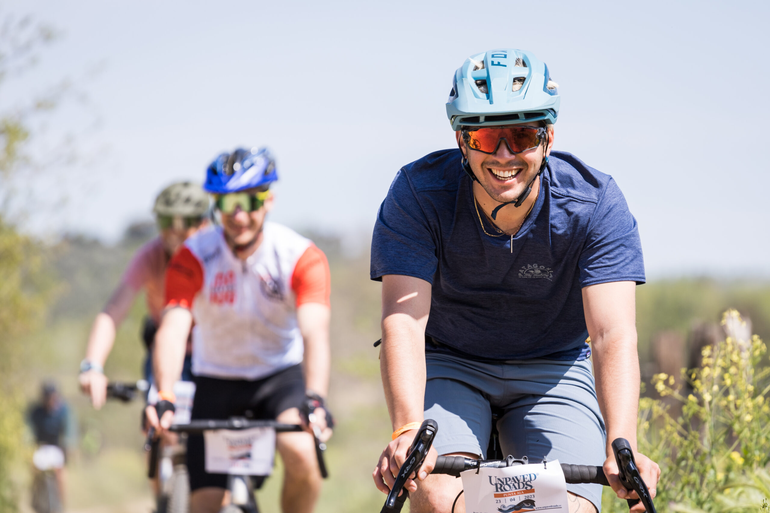 Gruppo di ciclisti sorridenti durante una gravel ride dell’evento Unpaved Roads a Punta Ala