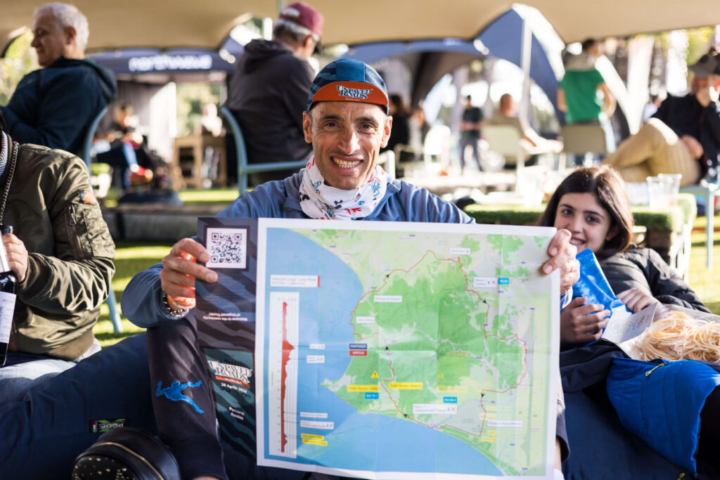 Partecipante di Unpaved Roads Punta Ala mostra la mappa del percorso gravel durante l’evento