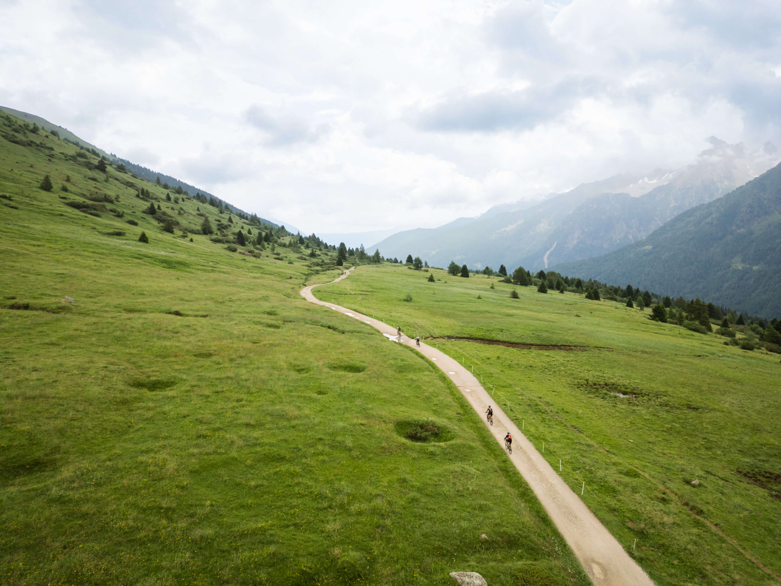 Spettacolare vista aerea del percorso gravel che si snoda tra le verdi vallate e le montagne della Val di Sole durante l'evento.