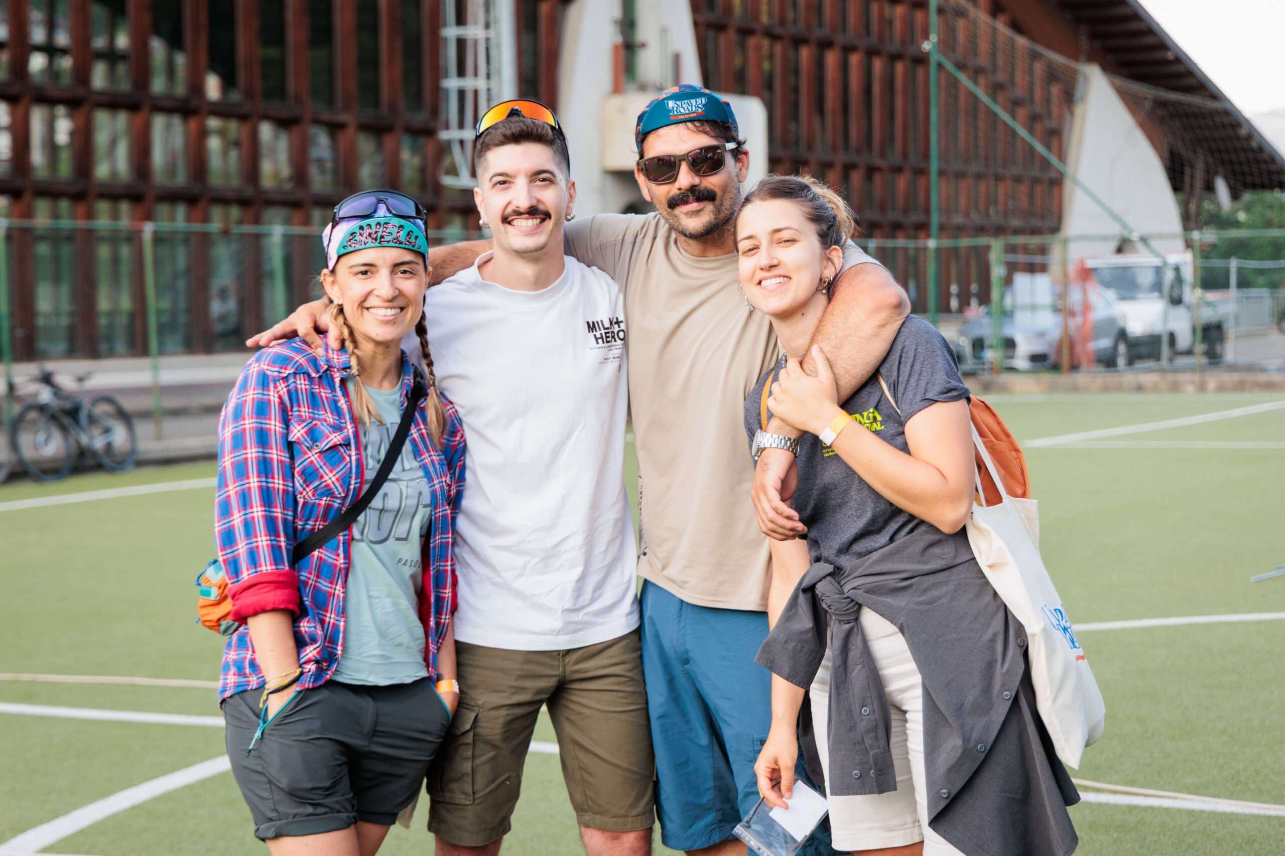 Un gruppo di amici sorridenti si abbraccia dopo l'evento, rappresentando lo spirito di amicizia e community del mondo gravel.
