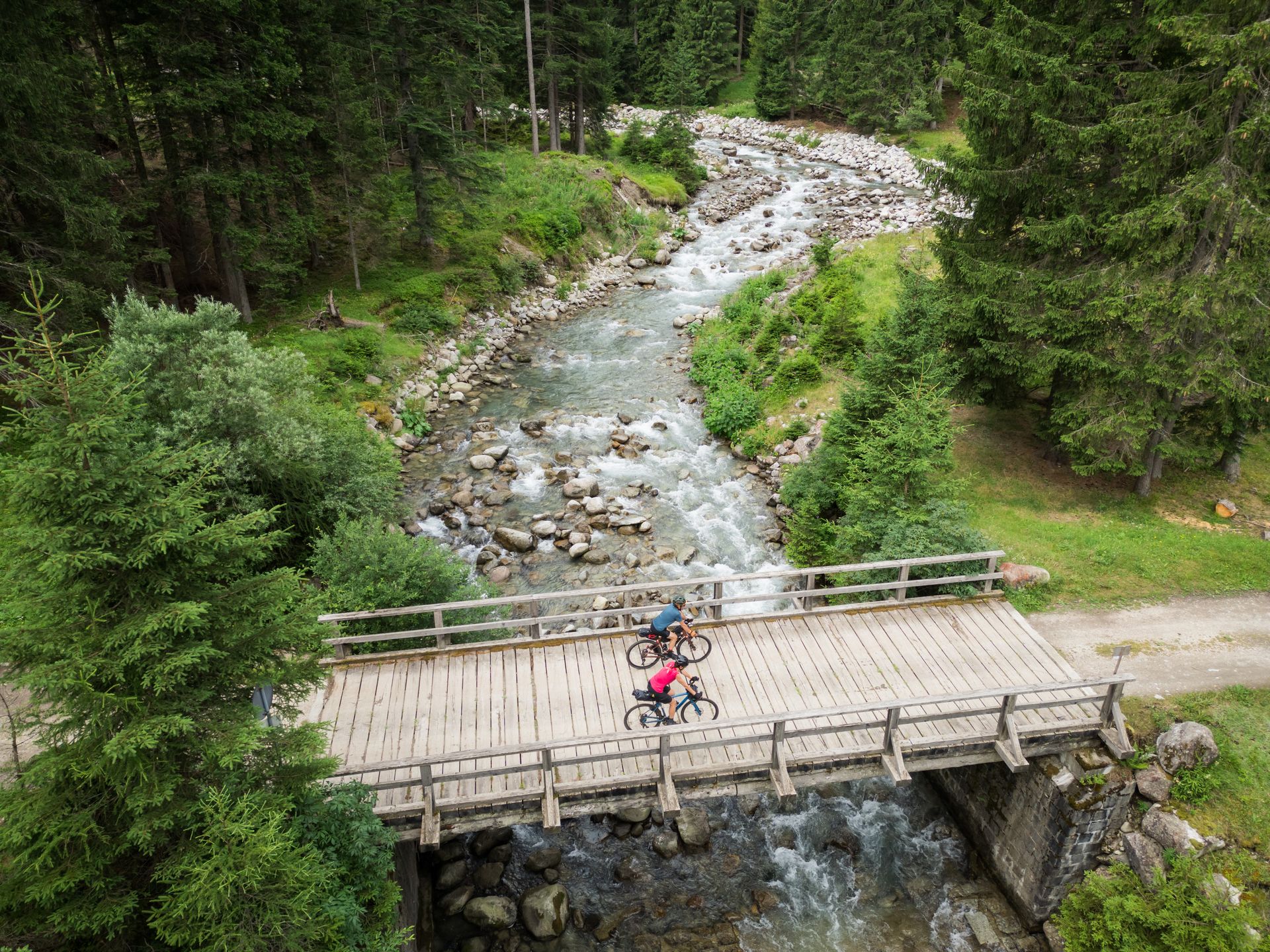 Vista aerea del gruppo di ciclisti gravel immersi nella natura della Val di Sole