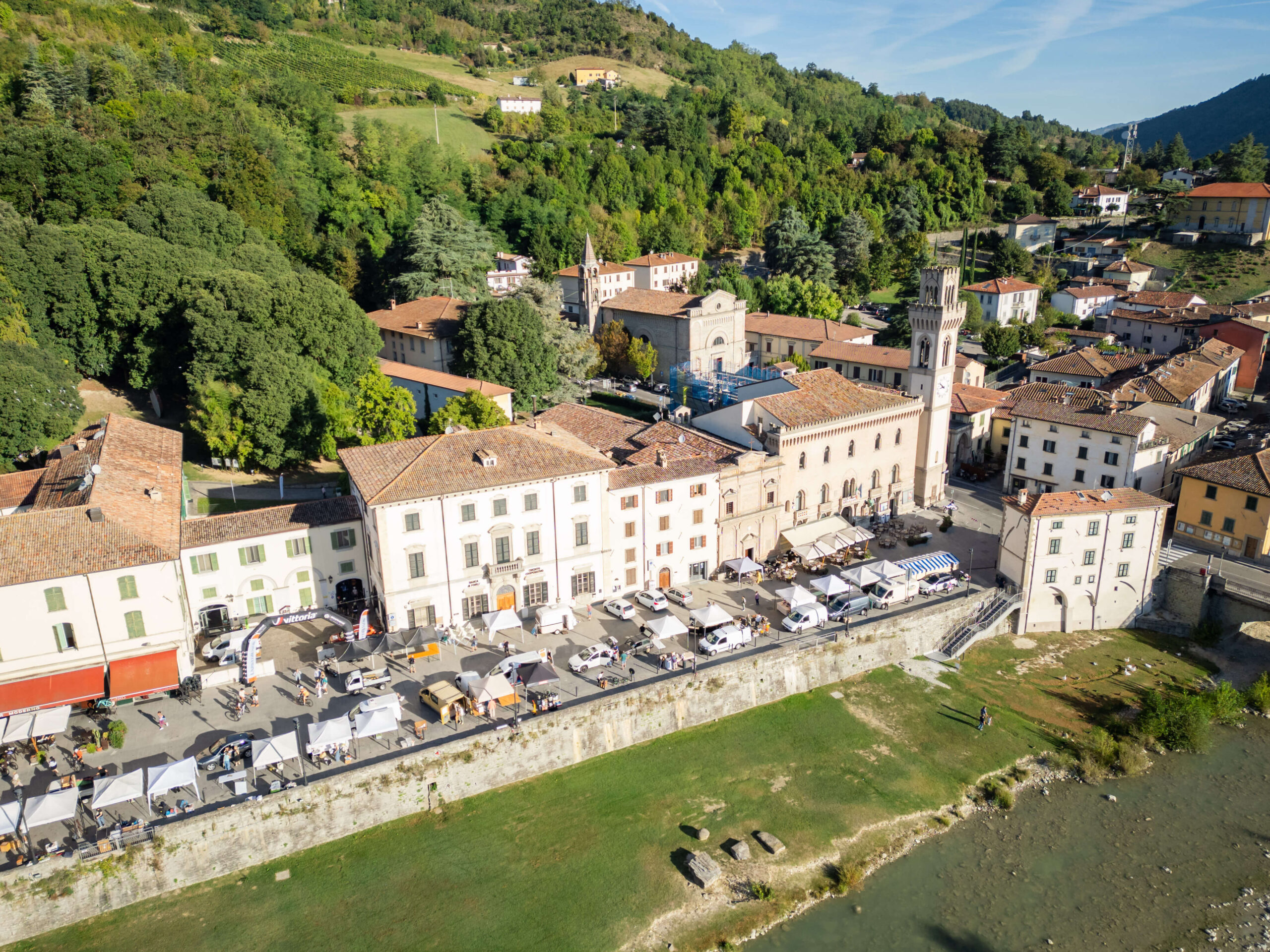 Vista aerea del village Unpaved Roads a Santa Sofia, con stand e partecipanti nel centro storico lungo il fiume Bidente.